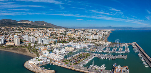 Aerial view of Benalmadena, Spain, featuring a vibrant marina with yachts, sandy beaches, a Ferris...