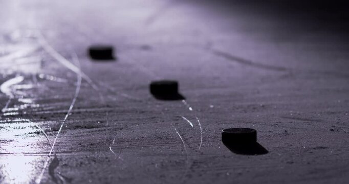 Stick handling pucks on the ice with hockey sticks