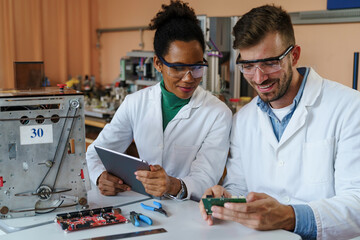Male Caucasian and Female Diverse Scientists Operating Robotics
