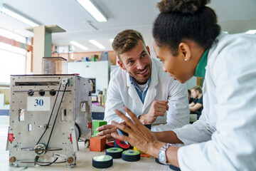Diverse Team Engineers Robot in Classroom Workshop