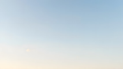 A minimal sky design with faint white clouds and a gradient from pale yellow to soft blue