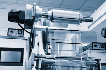 Automatic polyethylene plastic bag production machine with lighting effect. Close-up of the roller...