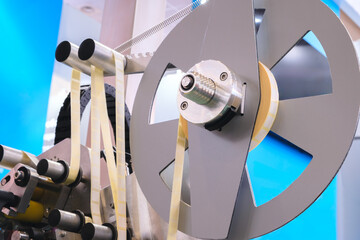 Fragment of the conveyor of sticking labeling machine. Abstract industrial background.