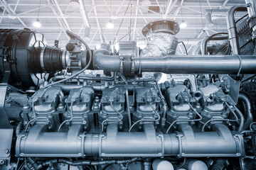 Big gas engine diesel generator electric power with many wires pipes industrial machine concept background