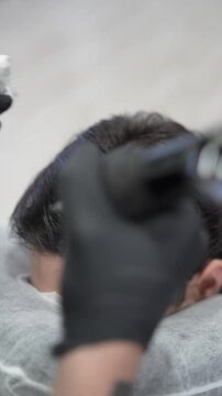 Plano detalle de tecnico de micropigmentacion capilar realizando trabajo en cabeza con pelo