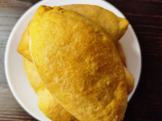 Delicious homemade pies with cabbage on a plate on a dark wooden table