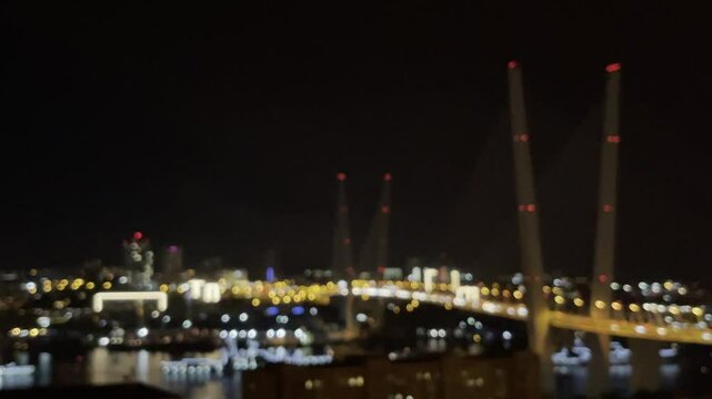 Bokeh blurred night city lights on road with big bridge over bay
