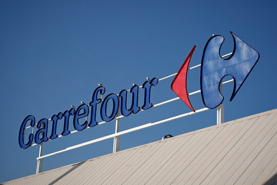 Finestrat, Spain - November 29, 2024: Carrefour logo sign on Carrefour supermarket on sky background. Carrefour is French multinational retail and wholesaling corporation
