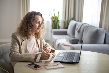 Modern business woman working online use laptop making notes e learning distance education at home