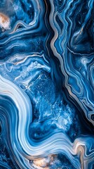Obraz premium Dynamic blue and gold abstract swirling pattern resembling ocean waves, showcasing movement and fluidity.