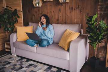 Obraz premium Charming young woman chatting happily indoors on a cozy weekend afternoon