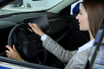 Naklejka premium Young woman inside new blue car in salon