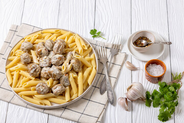 Ground chicken meatballs with penne pasta on plate