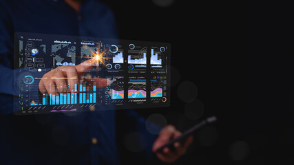 A man is pointing at a screen with a lot of numbers and graphs. Concept of data analysis and the...