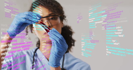 Holding test tube, scientist analyzing data with code image overlaid