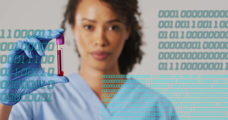 Holding blood sample, healthcare worker with binary code image over