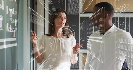 Analyzing data on screen, business professionals with futuristic interface image