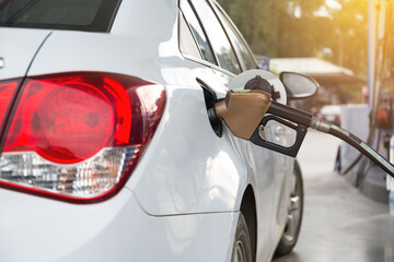 Fototapeta premium Transportation and ownership concept - man pumping gasoline fuel in car at gas station. hight price during war concept. .