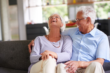 Hug, laughing and love with old couple on sofa in living room of home together for bonding or...
