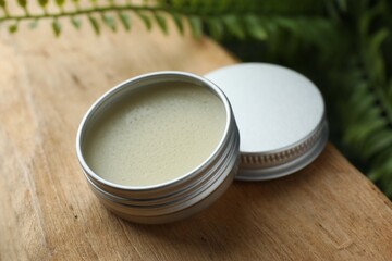 Natural solid perfume and plant on wood, closeup