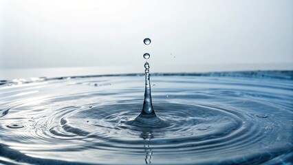 A single drop of water falls from a high place into a vast body of water creating ripples and waves on the surface, waterfall, liquid motion