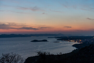 Tranquil sunset over a serene sea with island silhouettes under vibrant twilight sky. Concept of relaxation, nature beauty, and peaceful moments. High quality photo