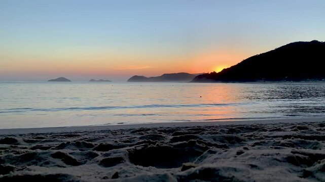 Final de tarde ap&oacute;s o p&ocirc;r do sol, com o c&eacute;u muito limpo e o mar quebrando suavemente na areia. Ao fundo, duas ilhas famosas do Litoral Norte: Ilha das Couves e As Ilhas.
