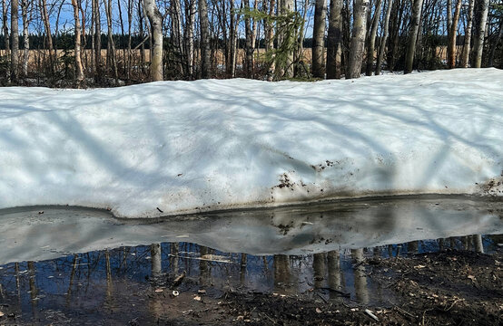 Reflection of snow pile on a walking path in Delta Junction, Alaska on a spring dya.