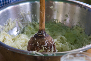 Unrecognizable person is demonstrating how to make a sourkraut from fresh cabbage.