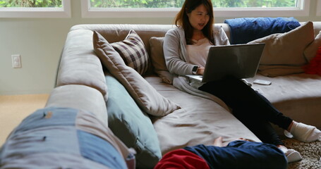 Obraz premium Mother and son using laptop in living room at home 4k