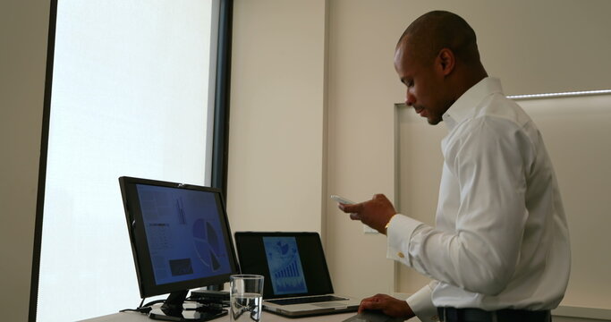 Businessman using mobile phone in office - Powered by Adobe