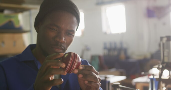 Front view close up of an African American man working in the workshop at a factory making cricket b - Powered by Adobe