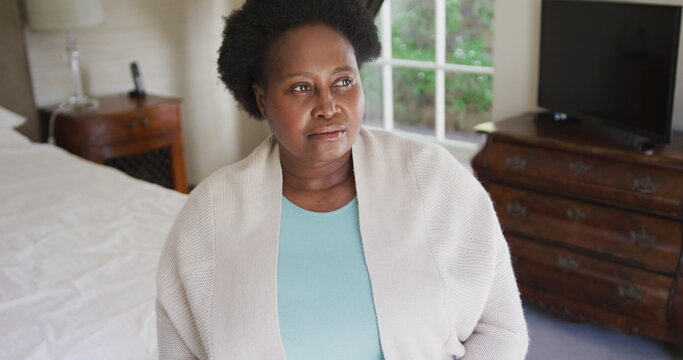 Thoughtful african american senior woman sitting on the bed at home - Powered by Adobe