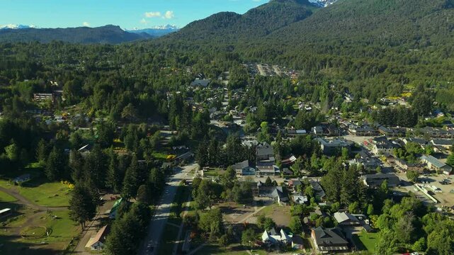 Scenic aerial view of Villa La Angostura's main urban area featuring Arrayanes Avenue. Nestled in Patagonia, Argentina, the image captures the charming blend of urban development and surrounding.