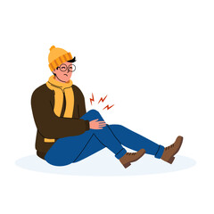 Man sitting on the ground holding his knee with signs of discomfort in a winter setting