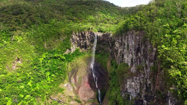 Picturesque flying over the mountain creek fall down from steep high cliff to wide green jungle valley. Cascade 500 Pieds waterfall also known as Cascade des Galets on Mauricius island in Indian ocean