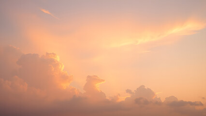 Obraz premium A sunrise background with golden clouds glowing softly against a light pink and blue sky 