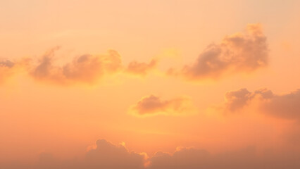 Fototapeta premium A sunrise background with golden clouds glowing softly against a light pink and blue sky 