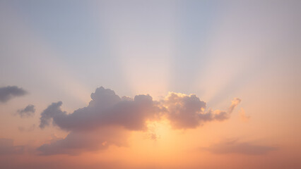 A sunrise background with golden clouds glowing softly against a light pink and blue sky 