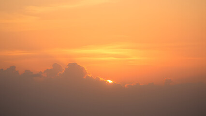 A sunrise background with golden clouds glowing softly against a light pink and blue sky 