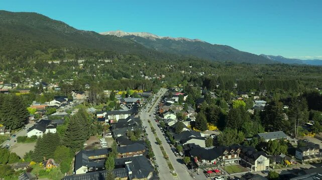 Scenic aerial view of Villa La Angostura's main urban area featuring Arrayanes Avenue. Nestled in Patagonia, Argentina, the image captures the charming blend of urban development and surrounding.