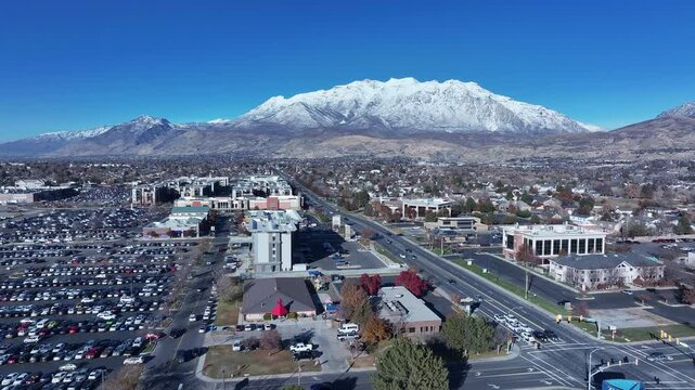 Aerial Residential apartments shopping Mt Timpanogos. Orem city, variety of stores businesses. Urban economy Malls, stores, residential neighborhoods, parks. High desert valley. Snow covered winter.