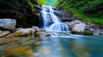 Fototapeta premium Stunning Waterfall Cascading Over Rocks in a Lush Green Forest with Crystal Clear Pool Below