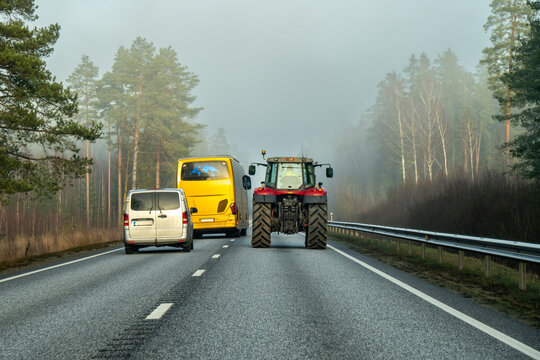 Autobus performs dangerous overtaking of the tractor by car and in highway fog.