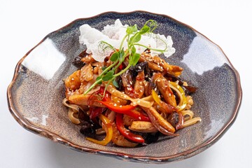 Stir-Fried Udon with Meat in Wok on a Plate Against a White Background