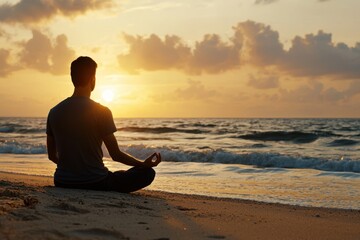 A man is sitting on the beach, meditating and enjoying the sunset