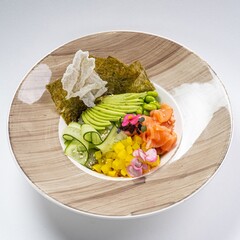  Salmon Poke Bowl with Cucumber, Nori, Beans, and Avocado Against a White Background