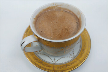 cappuccino coffee in a white glass on a white table, ready to be brewed