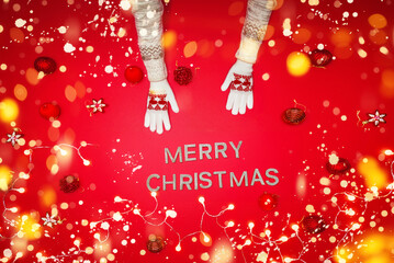 The girl is using the hand to hold the ball red decorations On a red background with christmas ornaments with led light. Top view. Christmas family traditions. Concept christmas.