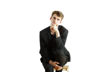 Young man in formalsuit sitting on a stool, hand resting on chin, posing thoughtfully, isolated on white, ideal for fashion or portrait concepts